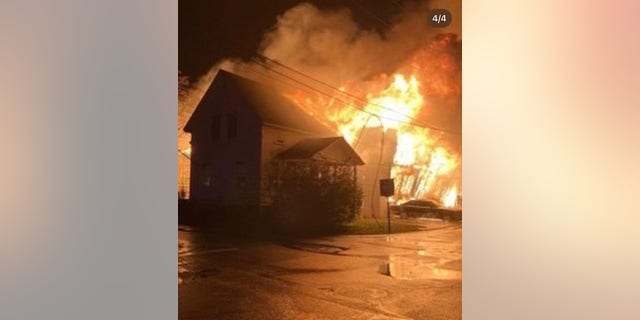 Flames engulf a nearby home after a fire ignited at the Old Mystic marina in Connecticut overnight.