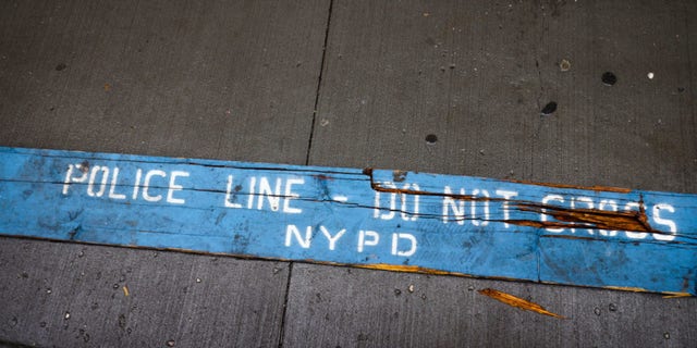 "Police line - do not cross NYPD" sign is seen laying on a street in New York, Oct. 25, 2022.