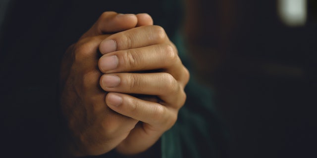 prayer hands in dark background