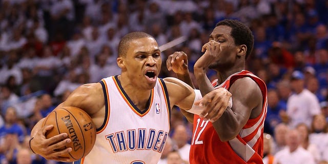 Russell Westbrook of the Thunder handles the ball under pressure from Patrick Beverley of the Houston Rockets during the NBA Playoffs on April 24, 2013, in Oklahoma City. The Thunder won, 105-102.