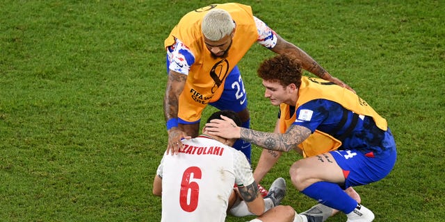 DeAndre Yedlin and Josh Sargent of the United States hug Saeid Ezatolahi of Iran after a FIFA World Cup Qatar 2022 Group B match at Al Thumama Stadium on November 29, 2022 in Doha, Qatar.