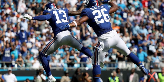 Teammates Odell Beckham Jr. (13) and Saquon Barkley (26) of the New York Giants celebrate after Beckham Jr. throws a touchdown to Barkley during a game at Bank of America Stadium Oct. 7, 2018, in Charlotte, N.C. 