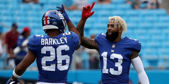 Odell Beckham (13) and teammate Saquon Barkley (26) of the New York Giants greet each other during warmups against the Carolina Panthers at Bank of America Stadium Oct. 7, 2018, in Charlotte, N.C.  