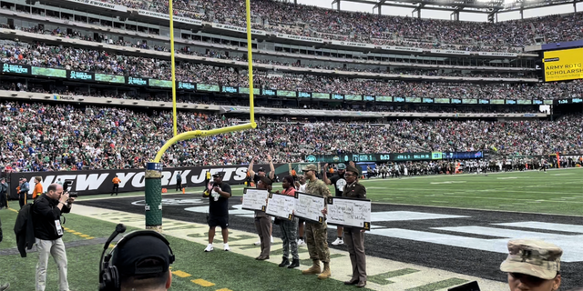 The four U.S. Army Minuteman Scholarship recipients claim their prize at the New York Jets Salute to Service game on Nov. 6, 2022.