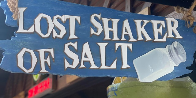 See in this image is a "Lost Shaker of Salt" sign at the bar in Margaritaville.