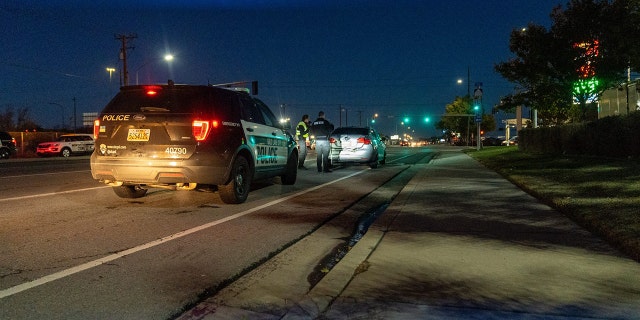 Police officers arrive at 919 West 2100 South to investigate the crash and attempted carjacking of the White BMW SUV.