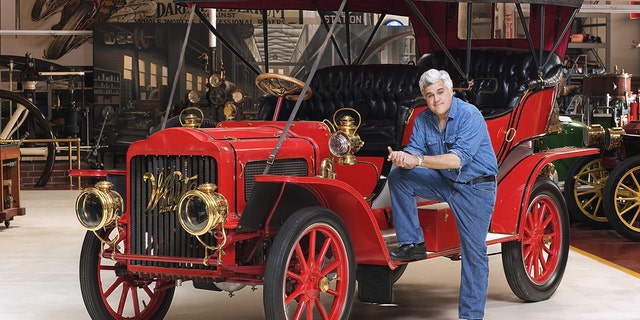 Jay Leno has hundreds of rare and vintage cars, and posed with a 1908 steam car.