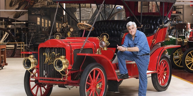 Jay Leno has hundreds of rare and vintage cars and posed with a steam car.