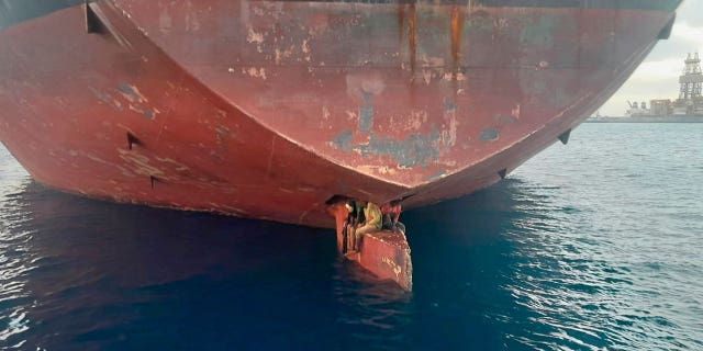 In this photo released on Tuesday, November 29, 2022, three men are shown perched on the helm of an oil tanker docked in the port of Las Palmas in the Canary Islands on Monday.