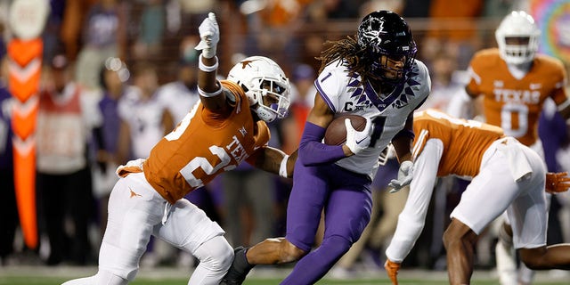 Quentin Johnston #1 of the TCU Horned Frogs runs after a catch while defended by Jahdae Barron #23 of the Texas Longhorns in the first quarter of the game at Darrell K Royal-Texas Memorial Stadium on November 12, 2022 in Austin, Texas. 