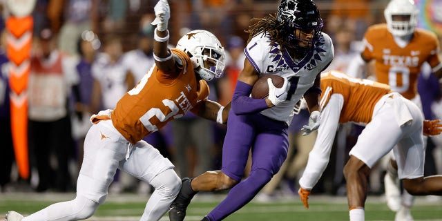 Quentin Johnston #1 of the TCU Horned Frogs runs after a catch while defended by Jahdae Barron #23 of the Texas Longhorns in the first quarter of the game at Darrell K Royal-Texas Memorial Stadium on November 12, 2022 in Austin, Texas. 