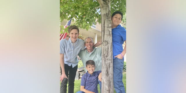 I'm so grateful my birth mom chose life 4 Riley with his adoptive father, Paul, and two adopted brothers, Will and Alex (kneeling), summer 2022.