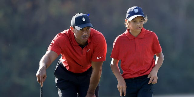 Tiger Woods and Charlie Woods look over a shot on the 15th hole during the final round of the PNC Championship at the Ritz-Carlton Golf Club Grande Lakes on December 19, 2021, in Orlando, Florida. 