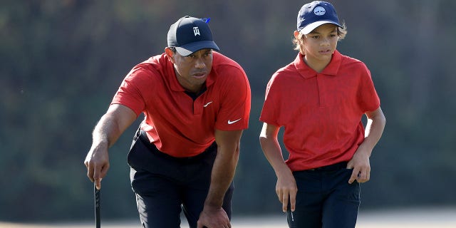 Tiger Woods and his son Charlie look over a shot on the 15th hole during the final round of the PNC Championship at the Ritz-Carlton Golf Club Grande Lakes in Orlando, Florida, on Dec. 19, 2021.