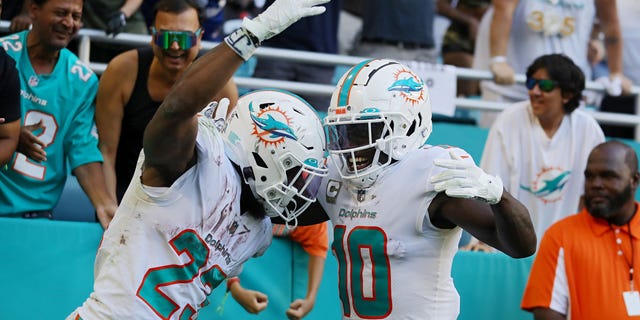 Jeff Wilson Jr. (23) celebrates with Tyreek Hill of the Miami Dolphins after a touchdown in the fourth quarter against the Cleveland Browns at Hard Rock Stadium on Nov. 13, 2022, in Miami Gardens, Florida.