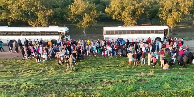 It shows a group of illegal immigrants gathered at the southern border of the United States. 