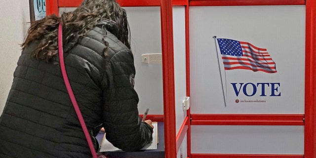 A voter fills out her ballot at the Utah County Election offices in Provo, Utah, on Nov. 4, 2022.