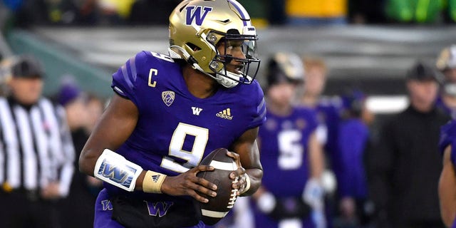 Washington quarterback Michael Penix Jr. (9) rolls away from Oregon defenders and looks for a receiver during the first half of an NCAA college football game Saturday, Nov. 12, 2022, in Eugene, Ore.