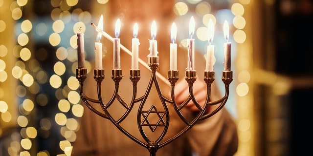 A child lighting the Menorah candles for Hanukkah celebration over the holiday.