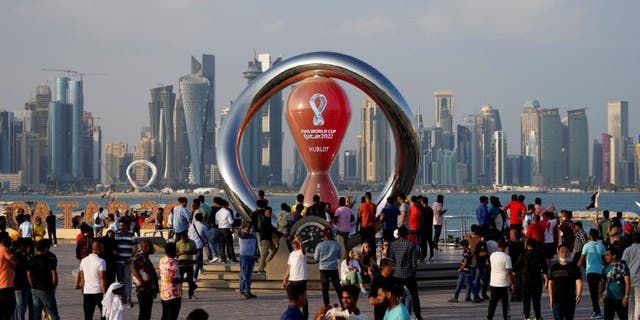   People gather around the official countdown timer showing the time remaining until kickoff of the 2022 World Cup, in Doha, Qatar