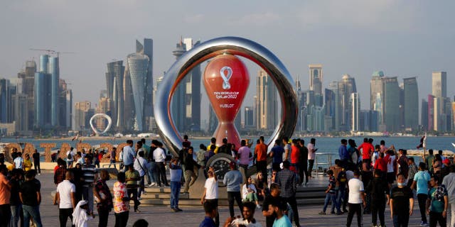   People gather around the official countdown timer showing the time remaining until kickoff of the 2022 World Cup, in Doha, Qatar