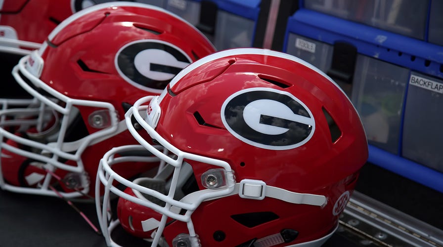 UGA football linemen wearing padded helmet covers designed to