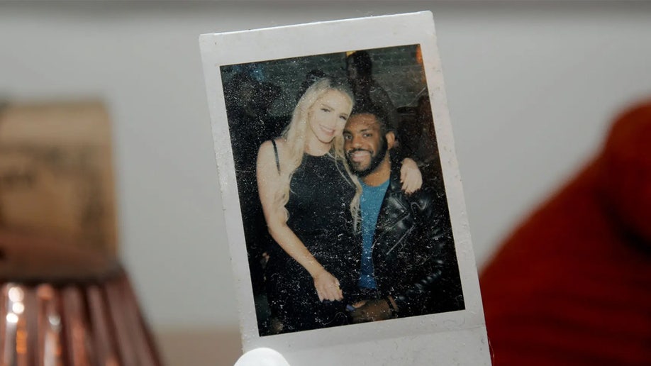 A Polaroid photo of Clenney sitting in Obumseli's lap.