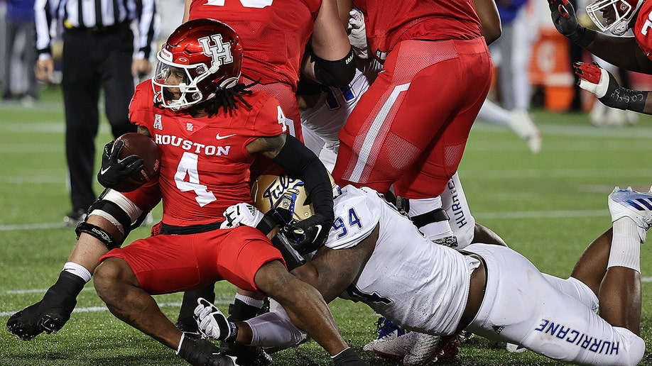 A Tulsa player tackling a Cougar