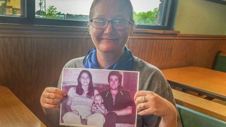 Holly Marie Clouse with photo of parents Dean and Tina