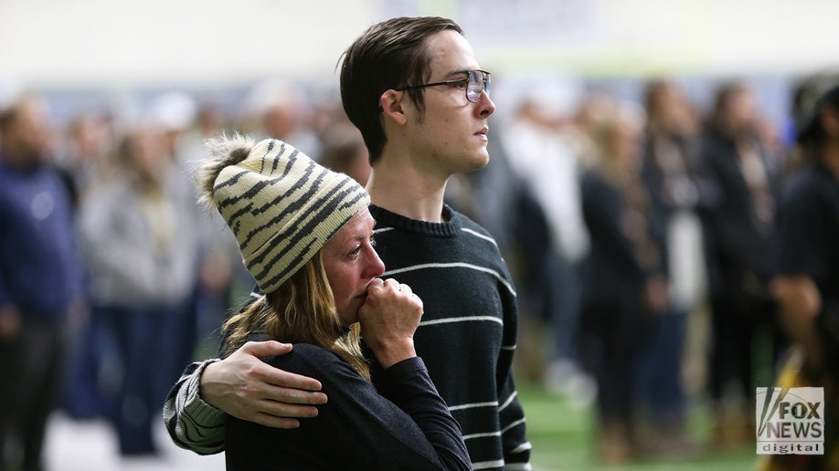 A man with his arm around a crying woman at the Idaho vigil