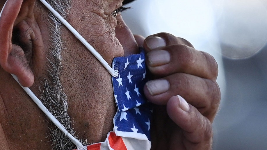 A Los Angeles man adjusts his American flag face mask