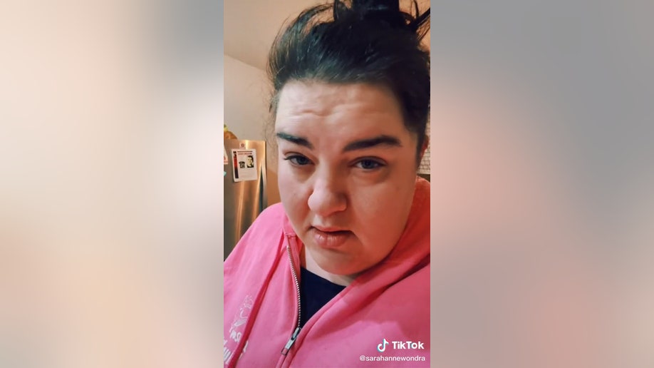Sarah Wondra records a TikTok video in front of Michael Vaughan missing flyer
