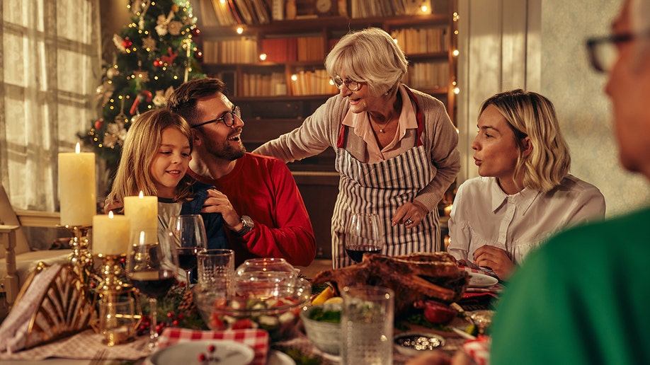 Family gathered around table with Christmas tree