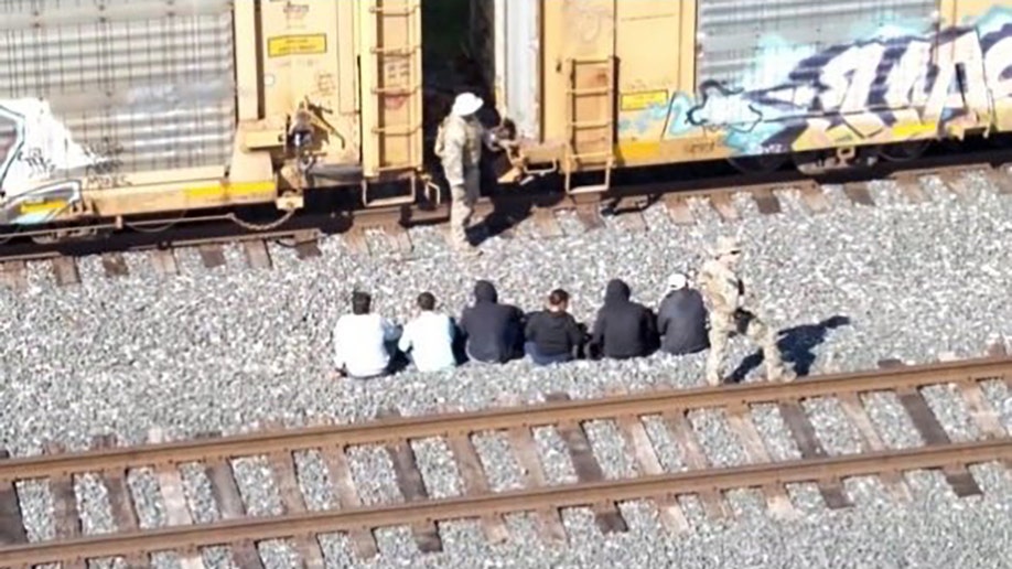 migrants sitting outside train