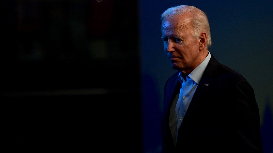 Biden walking in a dark area