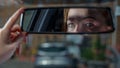 A woman who was carjacked earlier this year in Butchers Hill in Southeast Baltimore is reflected in a rearview mirror. (Karl Merton Ferron/Baltimore Sun/Tribune News Service via Getty Images)