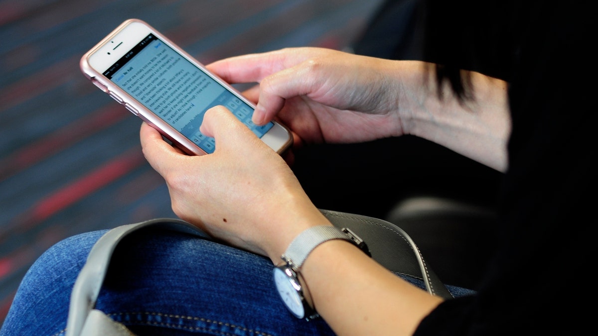 A woman uses her phone at an airport