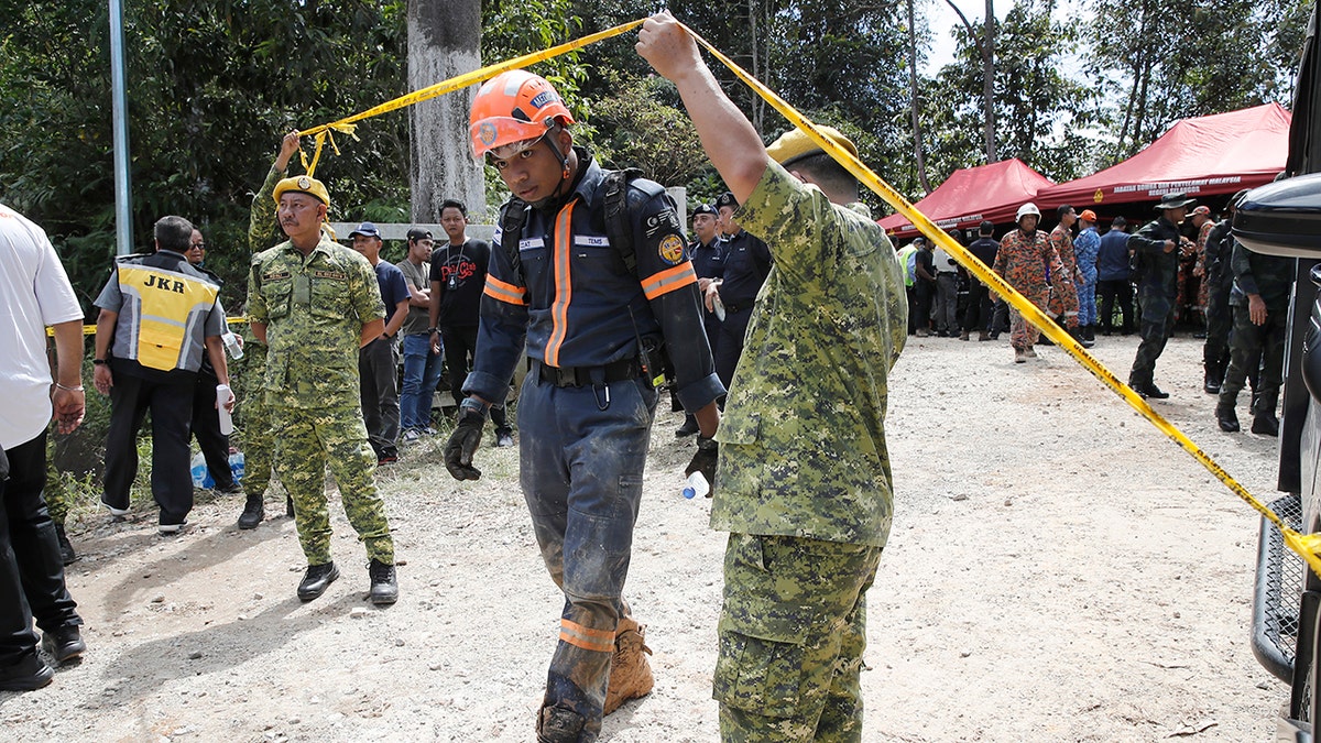 Rescue team steps under caution tape