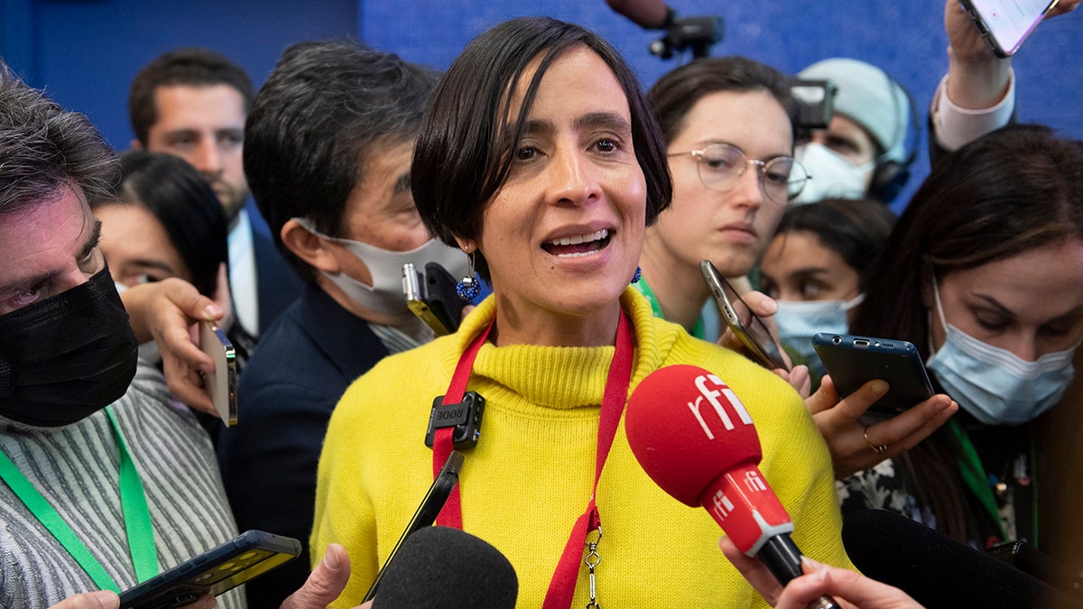 Lady in yellow sweater speaking into mic