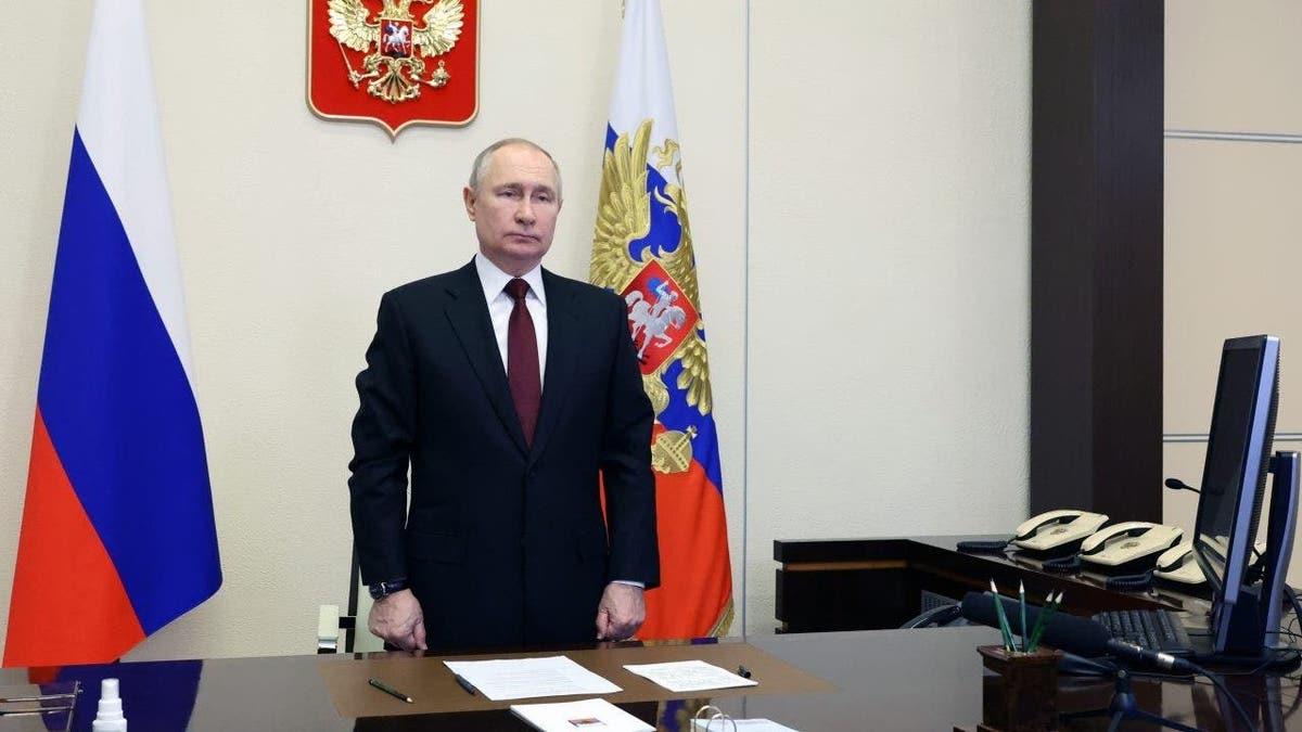 Putin standing in front of flags