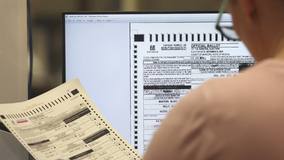 An Arizona election worker checks a ballot