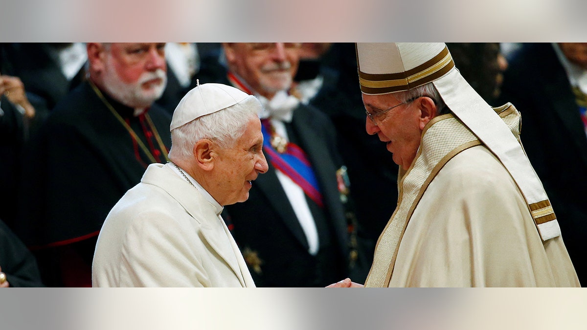 Pope Francis shakes hands with Pope Emeritus Benedict XVI in 2015