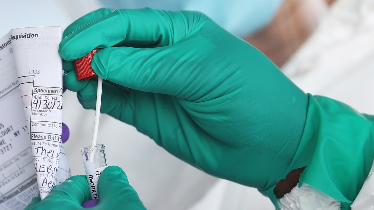 A Health Care Worker seals a coronavirus swab