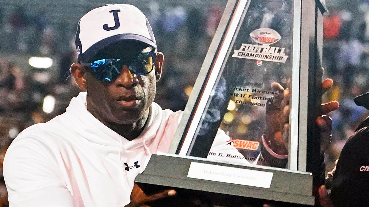 Deion Sanders holds the SWAC trophy