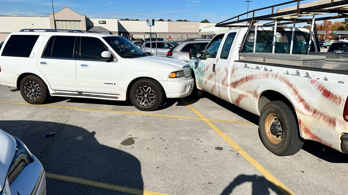 Two white vehicles have a fender bender in a Walmart parking lot