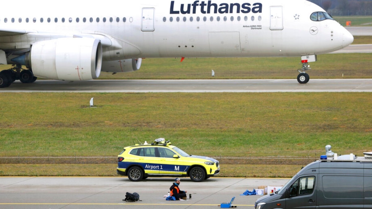 A climate activists sits on the road of a runway at an airport in Munich