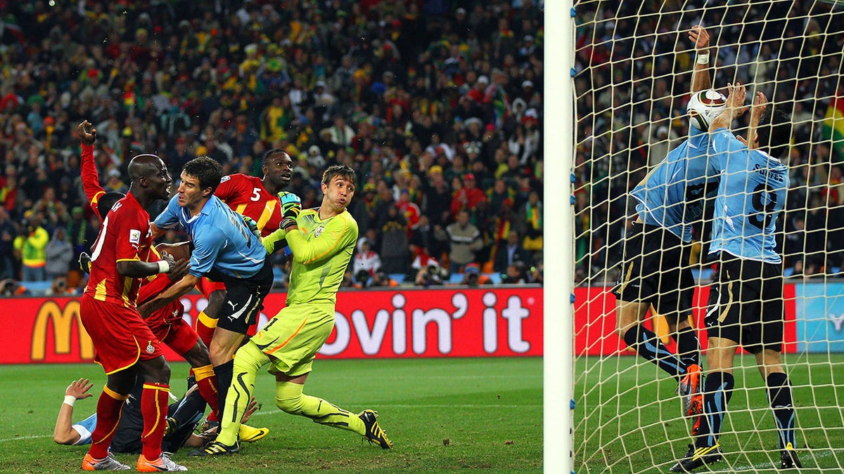 Luis Suarez uses his hands to stop a goal