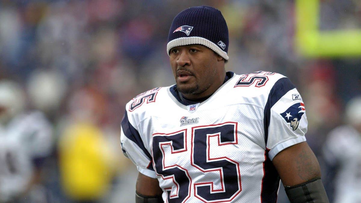 Willie McGinest stands on the sidelines during an NFL game