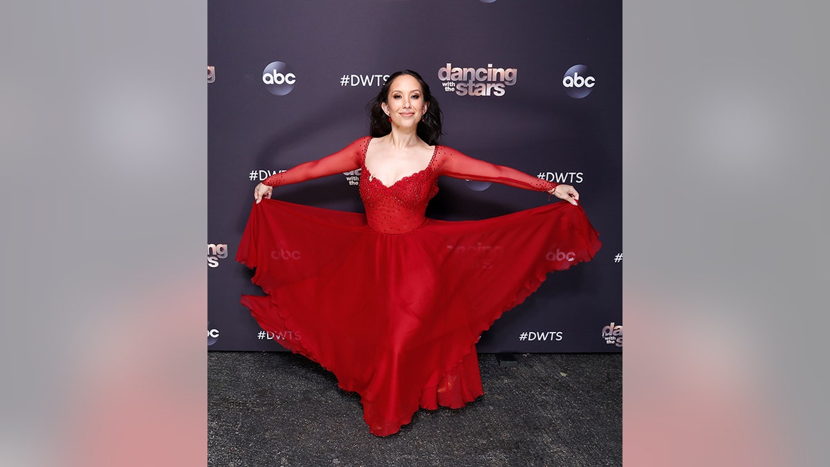 Cheryl Burke smiles in a red dress for "Dancing with the Stars"