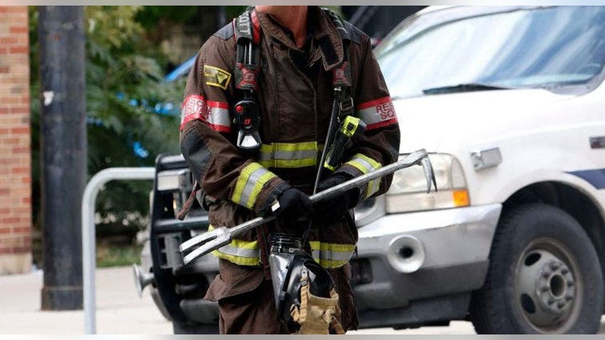 Firefighter carries Halligan pry bar